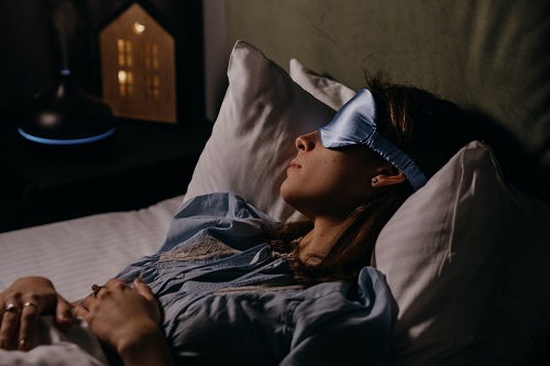 Woman wearing eye mask in bed